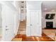 Bright foyer with hardwood floors, staircase, and view of living room fireplace at 10419 Chelsea Bay Dr, Charlotte, NC 28278
