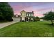 Charming two-story home with a well-manicured lawn and colorful sunset backdrop, creating a welcoming curb appeal at 105 Carmel Hills Dr, Gastonia, NC 28056