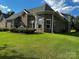 Well-maintained backyard featuring lush green grass, mature trees, and the home's exterior brick facade at 1108 Tarram Ct # 12, Lancaster, SC 29720
