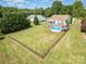 Aerial view of the property featuring a pool, fenced yard and large lawn surrounded by mature trees at 115 Meadow Lake Dr, Salisbury, NC 28146