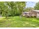 Lush green backyard with mature trees, landscaping, and a patio that is perfect for outdoor entertaining at 120 Labans Ln, Lincolnton, NC 28092