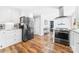 Modern kitchen boasts stainless steel appliances, white cabinetry, granite countertops, and wood-look flooring at 120 Labans Ln, Lincolnton, NC 28092