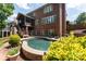 Brick home backyard with well-maintained pool, patio, and staircase to a screened porch at 132 Parkside Ln, Mooresville, NC 28117