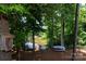 Scenic backyard with mature trees, a peaceful lake view, and covered bench at 132 Parkside Ln, Mooresville, NC 28117