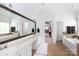 Bright bathroom featuring dual sinks, a soaking tub, and a large mirror with a wood frame at 132 Parkside Ln, Mooresville, NC 28117