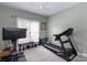 Exercise room with a treadmill, Peloton bike, weight bench, and a ceiling fan at 132 Parkside Ln, Mooresville, NC 28117