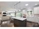 Bright kitchen boasts a center island, modern appliances, and blends seamlessly into the dining and living areas at 132 Parkside Ln, Mooresville, NC 28117