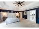 Spacious main bedroom with a tray ceiling, nightstands, lamps, and easy access to a bathroom at 132 Parkside Ln, Mooresville, NC 28117