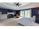 Spacious main bedroom featuring a fireplace, tray ceiling, and sitting area with views of the backyard at 132 Parkside Ln, Mooresville, NC 28117