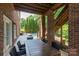 Covered patio with dining area, stone flooring, and staircase to the backyard pool at 132 Parkside Ln, Mooresville, NC 28117