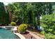 A luxurious pool surrounded by lush landscaping and mature trees at 132 Parkside Ln, Mooresville, NC 28117