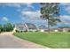 An exterior view of a suburban home on a lush green lawn with a long driveway and a mature tree at 1327 Springlake Rd, York, SC 29745