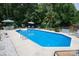 Sparkling pool with lounge seating and umbrellas, surrounded by mature trees and a fenced yard at 150 Wordsworth Way, Mooresville, NC 28115