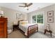 Bright bedroom features a ceiling fan, neutral walls, and a wooden framed bed at 1533 Ohara Plantation Ct, Dallas, NC 28034