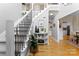 Bright foyer with wood floors, staircase, and decorative table displaying plants and artwork at 1533 Ohara Plantation Ct, Dallas, NC 28034