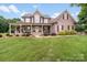 Charming brick home featuring a covered front porch and lush landscaping at 1533 Ohara Plantation Ct, Dallas, NC 28034