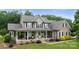 Charming brick home featuring a large front porch with decorative columns and lush landscaping at 1533 Ohara Plantation Ct, Dallas, NC 28034