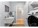 Well-lit laundry room featuring a sleek Samsung washer and utility sink at 1533 Ohara Plantation Ct, Dallas, NC 28034