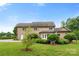 Home's rear exterior features a brick facade, well-maintained lawn, and mature trees at 1533 Ohara Plantation Ct, Dallas, NC 28034