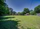 Expansive backyard offers ample green space, mature trees, and a playset, perfect for outdoor enjoyment and recreation at 1830 Huntington Pl, Rock Hill, SC 29732
