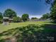 Expansive backyard with mature trees and a play structure at 1830 Huntington Pl, Rock Hill, SC 29732