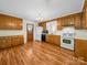 Functional kitchen featuring wood cabinets, white appliances, and a door leading to the backyard at 1830 Huntington Pl, Rock Hill, SC 29732
