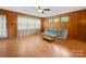 Comfortable living room featuring wood paneling, large windows, and a cozy sofa at 1830 Huntington Pl, Rock Hill, SC 29732