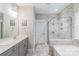 An elegant bathroom featuring a double vanity, soaking tub, and a glass-enclosed shower at 2112 Balting Glass Dr, Indian Trail, NC 28079