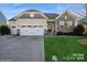 Charming single-Gathering home featuring a stone facade, two-car garage, and well-maintained landscaping at 2112 Balting Glass Dr, Indian Trail, NC 28079