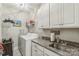 Well-organized laundry room with washer, dryer, granite countertops, and ample cabinet space at 2112 Balting Glass Dr, Indian Trail, NC 28079