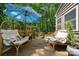 Inviting back deck with lounge chairs and an umbrella surrounded by a lush, wooded backyard at 2507 Connemara Dr, Matthews, NC 28105