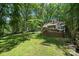 Expansive backyard features lush lawn, mature trees, playset, and a large wooden deck for outdoor enjoyment at 2507 Connemara Dr, Matthews, NC 28105