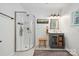 This bathroom has a glass door shower, gray vanity, a wooden stool and decorative mirror at 2507 Connemara Dr, Matthews, NC 28105