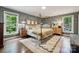 This bedroom features a four poster bed, hardwood floors and large windows that bring in plenty of natural light at 2507 Connemara Dr, Matthews, NC 28105