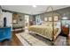 A bedroom featuring a four poster bed, hardwood floors, and a glimpse into the ensuite bathroom at 2507 Connemara Dr, Matthews, NC 28105