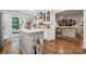 Open concept kitchen with white cabinets, hardwood floors, stainless appliances and seamless flow to the living area at 2507 Connemara Dr, Matthews, NC 28105