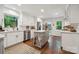 Bright, airy kitchen features white cabinets, subway tile backsplash, and gray island with hardwood floors at 2507 Connemara Dr, Matthews, NC 28105