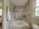 Bright bathroom with a tub, shower, towel, marble tiling and decor at 2666 Hill Ln, Gastonia, NC 28054