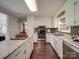 Bright kitchen features stainless steel appliances, white cabinets, dark backsplash, and light countertops at 2666 Hill Ln, Gastonia, NC 28054