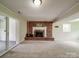 Spacious living room featuring a brick fireplace, neutral carpet, and natural light at 2666 Hill Ln, Gastonia, NC 28054
