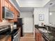 Well-equipped kitchen with sleek black appliances, granite countertops, wood cabinets, and stylish backsplash at 300 W 5Th St # 433, Charlotte, NC 28202