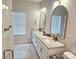 Modern bathroom featuring a double vanity with gold fixtures, arched mirrors, and tiled floor at 320 Lawrence Gray Rd, Charlotte, NC 28262