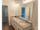 Bathroom featuring a double vanity with granite countertops, large mirror, and view to a bedroom at 320 Lawrence Gray Rd, Charlotte, NC 28262