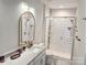 Bathroom showcasing a white vanity, framed mirror, glass enclosed shower with tile surround, and gold fixtures at 320 Lawrence Gray Rd, Charlotte, NC 28262