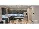 Stylish kitchen with green cabinets, stainless steel appliances, a center island, and wood-style floors at 320 Lawrence Gray Rd, Charlotte, NC 28262
