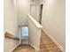 Stairway leading to the upper level, featuring wood steps and a white railing at 320 Lawrence Gray Rd, Charlotte, NC 28262