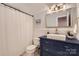 This elegant bathroom offers a navy vanity with brass hardware, marble style walls, and modern fixtures at 3214 Tilley Morris Rd, Matthews, NC 28105