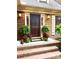 Inviting front entrance with a dark wood door, sconces, and charming decorations at 3214 Tilley Morris Rd, Matthews, NC 28105