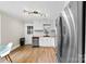 Open kitchen with white cabinets, stainless steel dishwasher and refrigerator plus modern countertops and lighting at 403 W 2Nd St, Cherryville, NC 28021