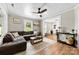 Spacious living room featuring a ceiling fan, a sectional sofa, and wood flooring at 403 W 2Nd St, Cherryville, NC 28021